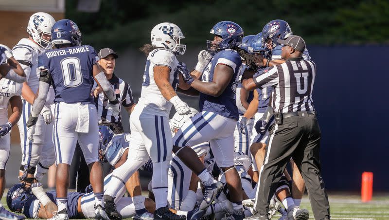 Players from the Utah State Aggies and the UConn Huskies push one another after a dead play at the Maverik Stadium in Logan on Saturday, Aug. 27, 2022. The Aggies won 31-20.