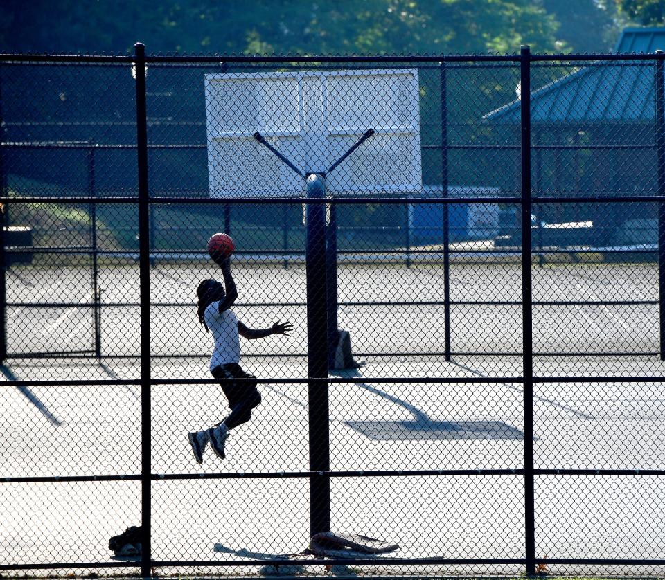 As the early morning heat builds and the haze worsens, Tyler Boafo, 24, of Worcester, gets some basketball in at Greenwood Park in Worcester before the worse of the heat Thursday.