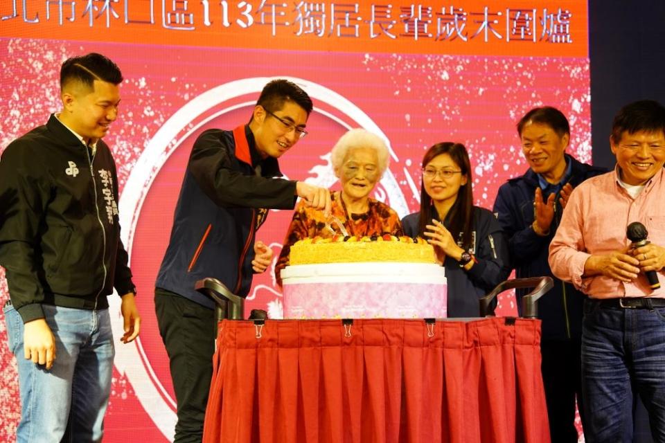 《圖說》林口區長廖武輝(左2)與居住在湖南里高齡92歲的陳奶奶(左3)一起切生日蛋糕。〈林口區公所提供〉