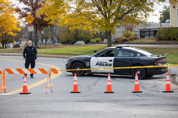 LEWISTON, MAINE - OCTOBER 26: A police officer blocks access to the road to Sparetime Recreation on October 26, 2023 in Lewiston, Maine. Police are still searching for the suspect in the mass shooting, Robert Card, who killed over 15 people in two separate shootings.  (Photo by Scott Eisen/Getty Images)