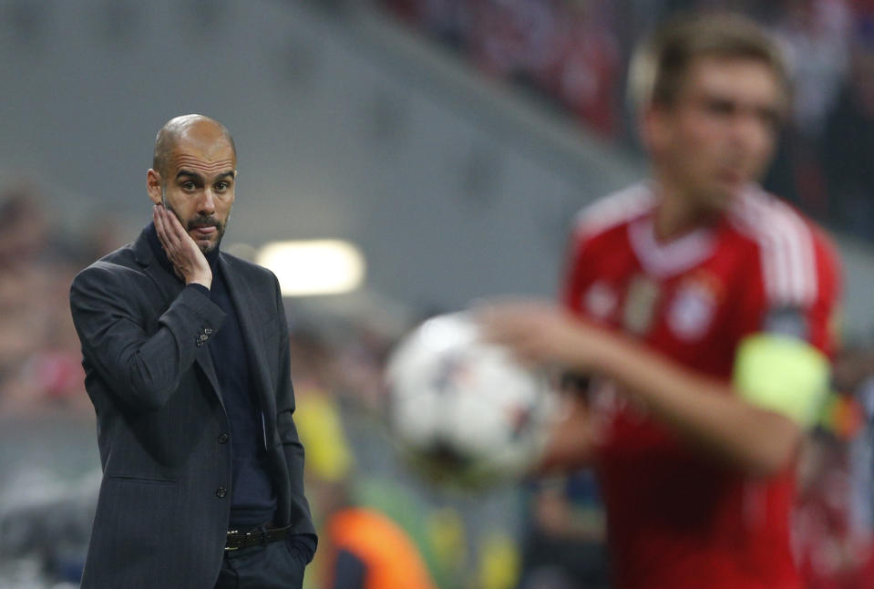 Bayern head coach Pep Guardiola, left, looks to team captain Philipp Lahm during the Champions League semifinal second leg soccer match between Bayern Munich and Real Madrid at the Allianz Arena in Munich, southern Germany, Tuesday, April 29, 2014. (AP Photo/Matthias Schrader)