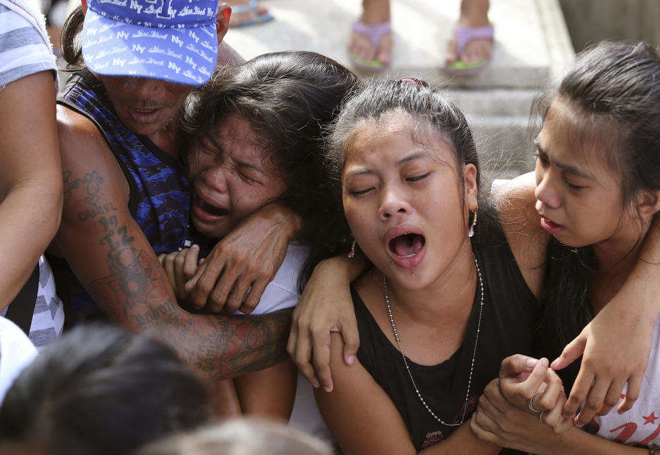 FILE - Relatives and friends grieve at the funeral of an alleged drug suspect Robert Manuel Jr. at the Manila's North Cemetery, Philippines on Sept. 12, 2016. Manuel was killed with two others during a buy-bust police operation as part of the continuing "War on Drugs" campaign. An International Criminal Court chief prosecutor, Karim Khan, said on June 24, 2022 that he has sought authorization from the court to resume an investigation into drug killings as a possible crime against humanity, from Nov. 1, 2011 when outgoing Philippine President Rodrigo Duterte was still a Davao mayor to March 16, 2019. (AP Photo/Aaron Favila, File)