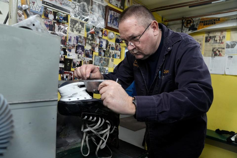 Joseph Lemay checks the alignment as he fastens a skate in the sharpening machine he works in the basement of his family's small house in the shadow of Mount St. Charles Academy, where many former customers played and then moved on to the NHL.