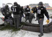 Players from the Hamilton Tiger-Cats try and warm up in the extreme cold during the team practice in Regina, Saskatchewan, November 20, 2013. The Saskatchewan Roughriders will play the Hamilton Tiger-Cats in the CFL's 101st Grey Cup in Regina November 24. REUTERS/Todd Korol (CANADA - Tags: SPORT FOOTBALL)