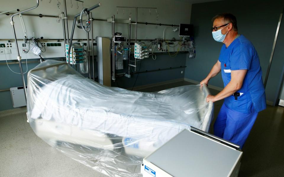 A member of the medical staff prepares a room reserved for patients suffering from the coronavirus disease (COVID-19) in an intensive care unit at St.-Antonius-Hospital in Eschweiler, Germany - REUTERS