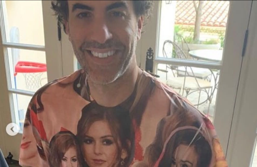 Sacha Baron-Cohen posing in his unique T-shirt to celebrate 20 years with Isla Fisher credit:Bang Showbiz