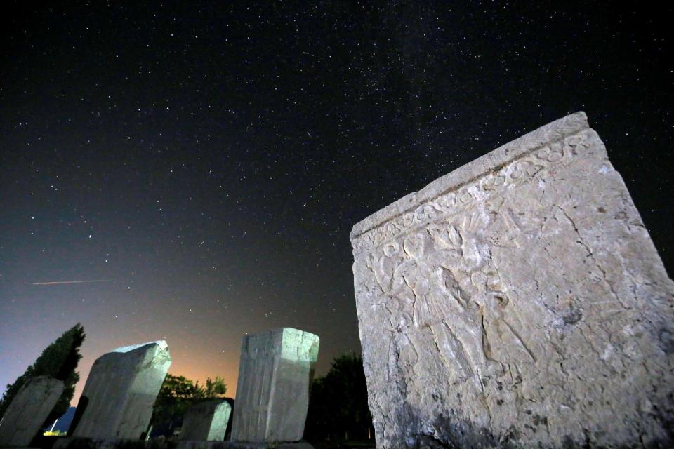 A meteor streaks past stars in the night sky above medieval tombstones during the Perseid meteor shower in Radimlja near Stolac, Bosnia and Herzegovina (Reuters)