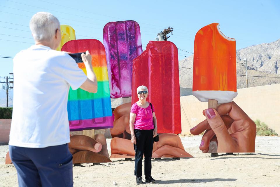 Martha and Jerry McCullough take photographs March 30, 2021 at the new art installation "Popsicles" by John Cerney on Sunny Dunes Road in Palm Springs.