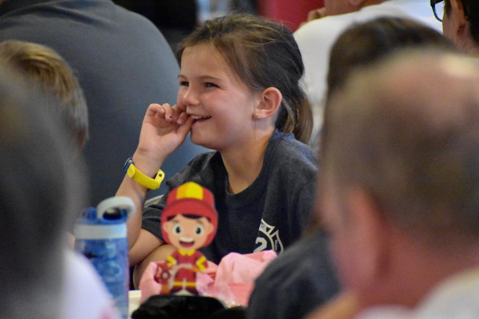 Fisher Bork, 6, grins during a retirement party for her grandfather, Calabash Fire Department Chief Randall Bork, and Assistant Chief Jim Bruno on May 27, 2022, in Calabash.