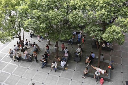 People rest under the trees outside a hospital in Shanghai, September 1, 2014. REUTERS/Aly Song