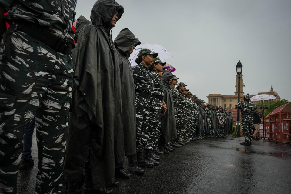 Indian paramilitary soldiers stand guard at a barricade to prevent lawmakers from India's opposition Congress party from moving ahead during a protest in New Delhi, India, Friday, Aug. 5, 2022. (AP Photo/Altaf Qadri)