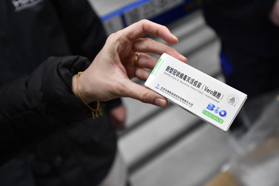 A woman holds a packet containing vials of the COVID-19 vaccine developed by the Chinese state-owned company Sinopharm at a Hungarian pharmaceutical wholesaler in Budapest, Hungary, Tuesday, Feb. 16, 2021. A shipment of COVID-19 vaccines produced in China arrived in Hungary on Tuesday, making it the first of the European Union's 27 nations to receive a Chinese vaccine. (Marton Monus/MTI via AP)
