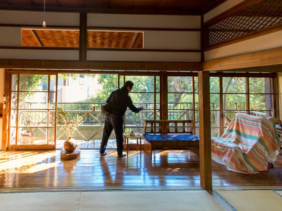 man opens sliding glass door window in living room