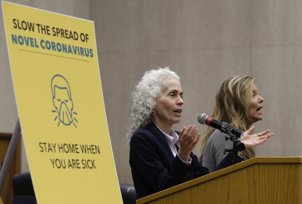 FILE - In this March 12, 2020, file photo, Los Angeles County Public Health Director Barbara Ferrer, left, takes questions at a news conference in Los Angeles. At right is Niago Wilson, a sign language interpreter. California officials are blaming a backlog in Los Angeles County for a sudden doubling in positive coronavirus cases and uptick in the state's positivity rate last week, but said lower numbers released Monday, Oct. 26, 2020, are accurate. (AP Photo/Damian Dovarganes, File)