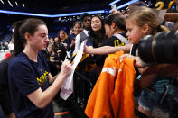 Indiana Fever guard Caitlin Clark signs autographs for fans before the start of WNBA basketball game against the New York Liberty, Saturday, May 18, 2024, in New York. (AP Photo/Noah K. Murray)