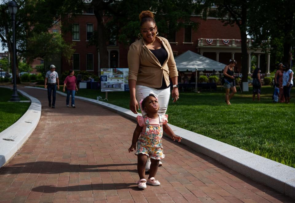 Myoline Zimanche, originally from Haiti, walks with her 17-month-old daughter Friday, July 1, 2022, along the Presidential Promenade at the Benjamin Harrison Presidential Site in Indianapolis. 