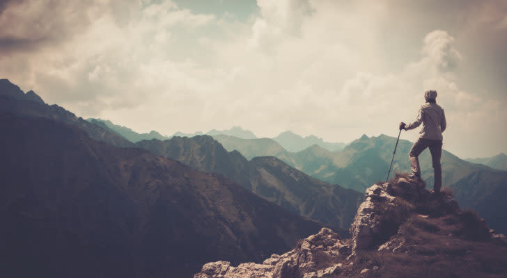 A photo of a person on the peak of a mountain.