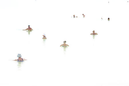 Tourists dip in the Dead Sea, Israel April 15, 2016. The picture was created by exposing for the shadows on a hazy day. REUTERS/Baz Ratner SEARCH "BAZ SEA" FOR THIS STORY. SEARCH "WIDER IMAGE" FOR ALL STORIES.