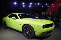 Poeple gather around a 2015 Dodge Challenger after it is introduced at the New York International Auto Show in New York, Thursday, April 17, 2014. (AP Photo/Seth Wenig)