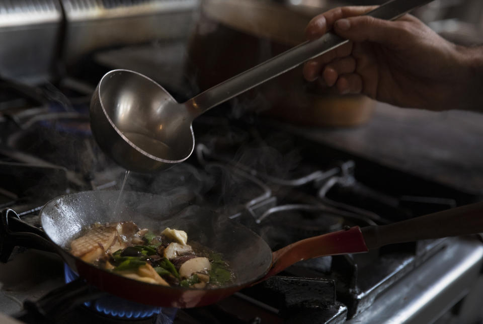 Chef Benjamin Gaugue, creates a dish combining different varieties of mushrooms and microgreens from Le Champignon de Bruxelles at his restaurant, De Bruxelles et D'ailleurs, in Brussels, Friday, Feb. 14, 2020. Gaugue is not only seduced by the savory greens, he also sees the ecological side of a project which implements a form of circular economy in an urban context. (AP Photo/Virginia Mayo)