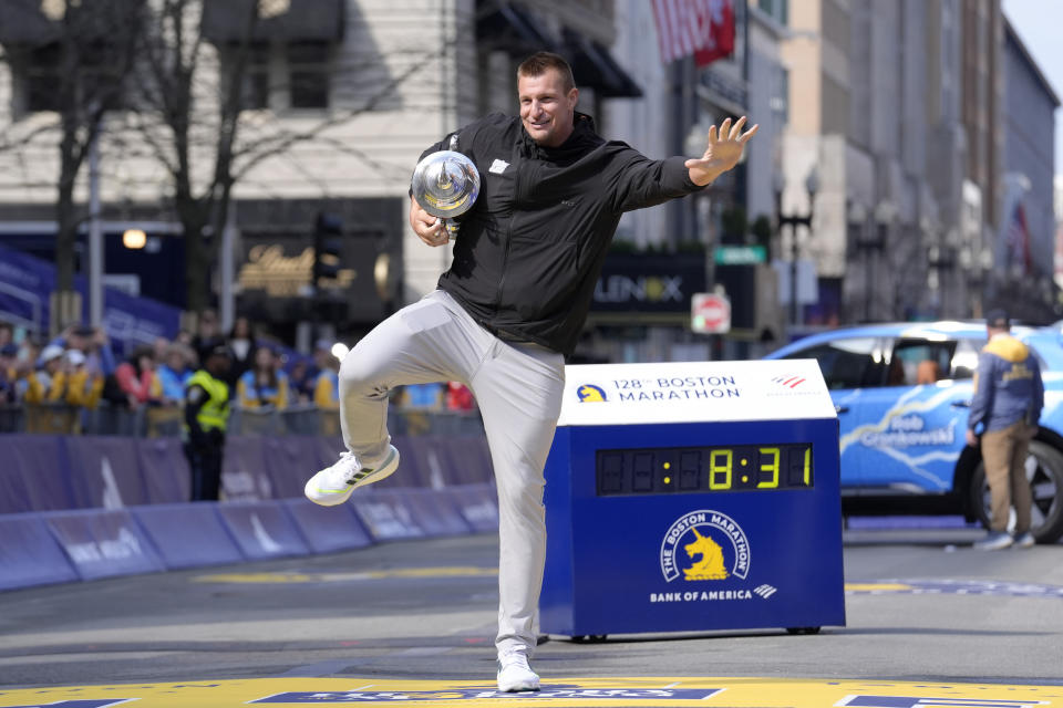 Former New England Patriots NFL football player Rob Gronkowski holds the Boston Marathon trophy at the finish line of the Boston Marathon, Monday, April 15, 2024, in Boston. Gronkowski is grand marshal of the race. (AP Photo/Steven Senne)