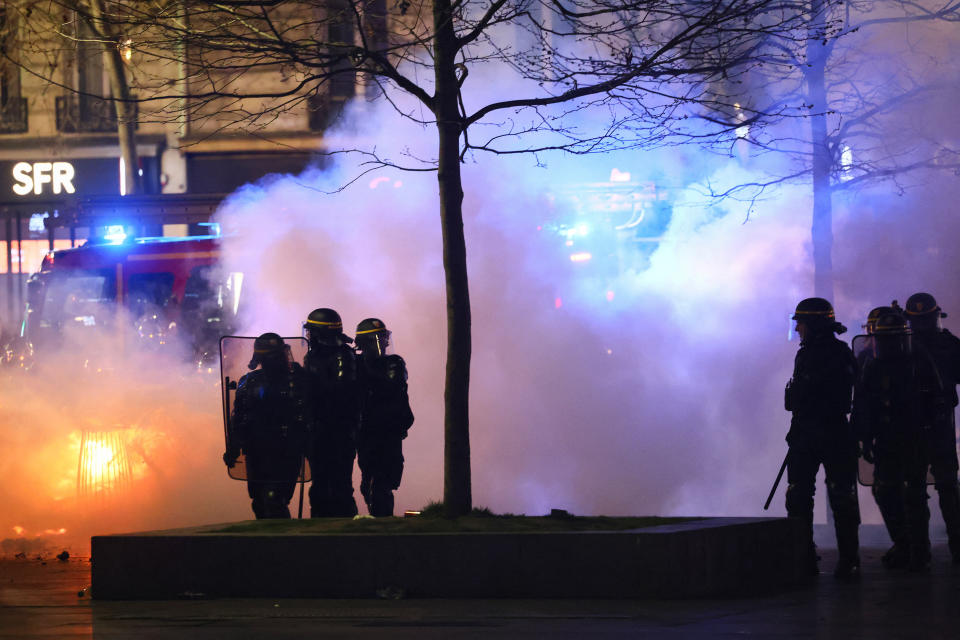 French police officers stand near a fire, as protesters gather at Place de la Republique during a demonstration, the day after the pension reform was adopted as the French Parliament rejected two motions of no-confidence against the government, in Paris, France, March 21, 2023. REUTER/Yves Herman