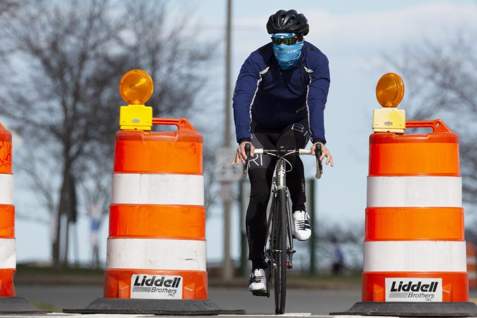 A man rides a bicycle on Day Boulevard which has been closed to traffic to reduce crowding on the adjacent sidewalk and allow social distancing, Saturday, April 11, 2020, in Boston. (Michael Dwyer/AP)