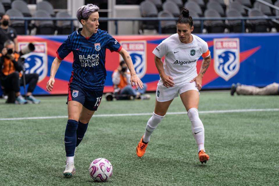 OL Reign forward Megan Rapinoe, left, dribbles the ball against NJ/NY Gotham FC defender Ali Krieger, right, during an NWSL game on May 21, 2023.