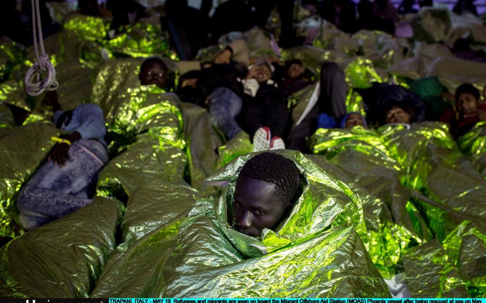 Refugees and migrants are seen on board the Migrant Offshore Aid Station (MOAS) "Phoenix" vessel after being rescued at sea on May 19, 2017 in Trapani, Italy. - Credit: Getty Images