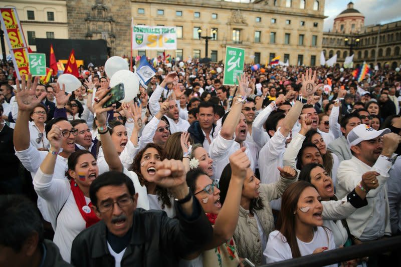 哥倫比亞首都波哥大的民眾透過大螢幕收看停火協議簽署實況，現場響起陣陣歡呼。（美聯社）