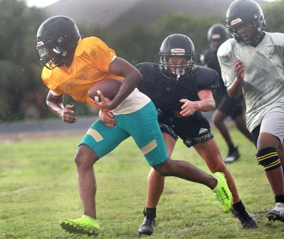 Pine Ridge High quarterback Alex Johnson runs for some yards in a light rain, Monday August 14, 2023 during practice.