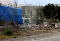 Wreckage lies on the ground in front of a Turkish millitary station covered by a tarpaulin after a suicide atack on August 2, 2015 in the eastern town of Dogubeyazit