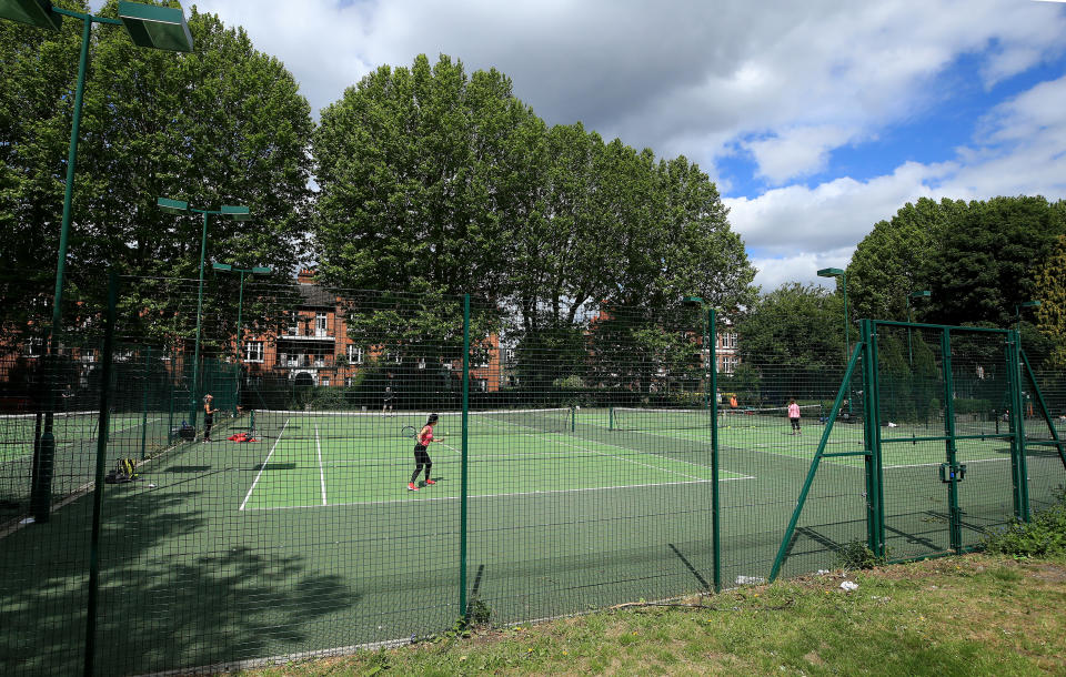 People play tennis at Rocks Lane Bishops Park Tennis Centre in Fulham, London.