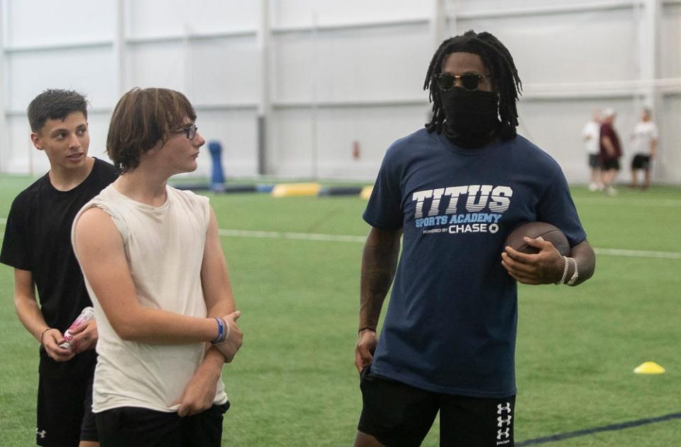 Darnell Savage of the Green Bay Packers speaks with a young football player at a free NFL clinic for youths at Chase Fieldhouse, Friday, June 17, 2022.