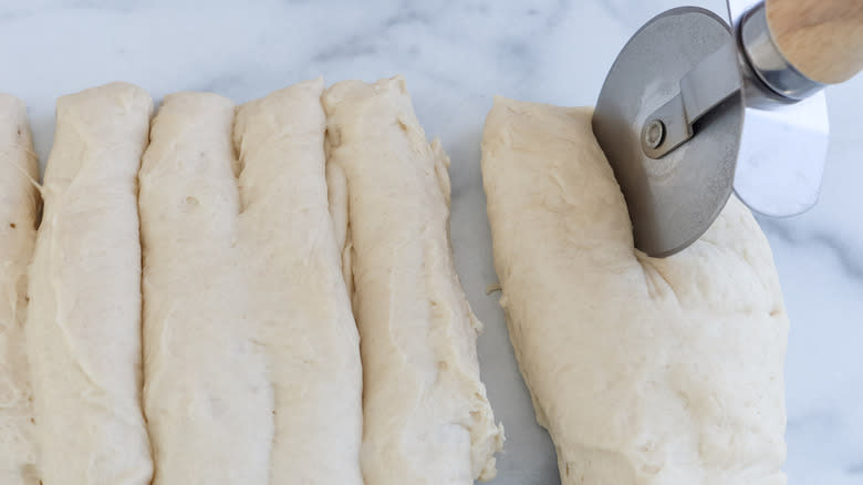 pizza cutter cutting dough