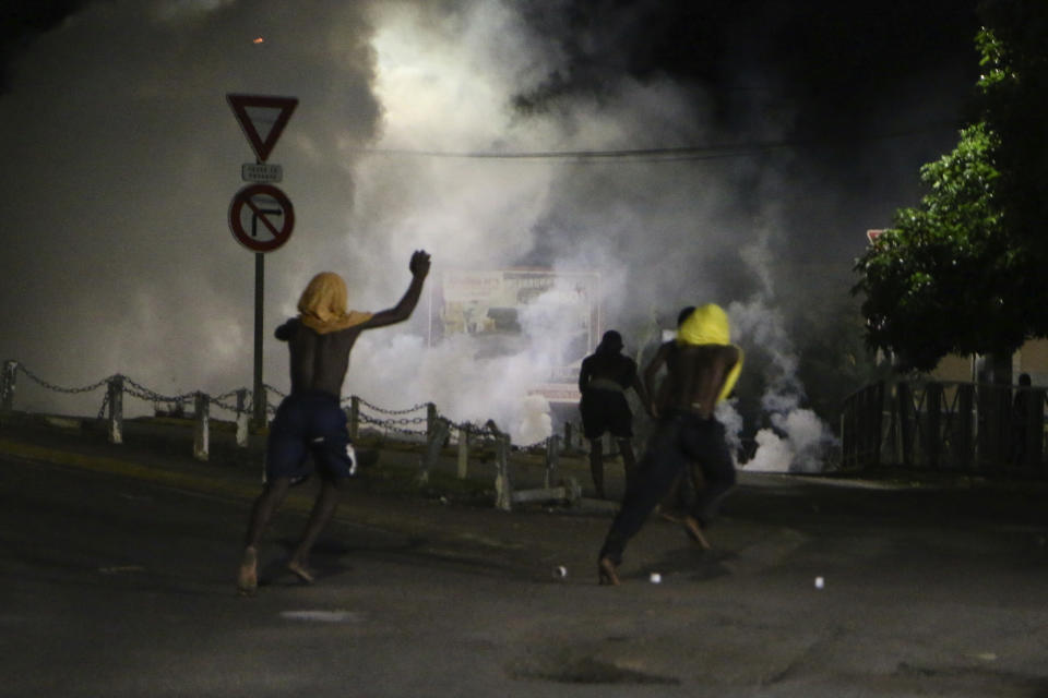 Youth run away during a scuffle with French gendarmes in Brandrele, in the French Indian Ocean territory of Mayotte, Thursday, April 27, 2023. France is facing a migration quagmire on the island territory of Mayotte off Africa’s east coast. The government sent in 2,000 troops and police to carry out mass expulsions, destroy slums and eradicate violent gangs. But the operation has become bogged down and raised concerns of abuse, aggravating tensions between local residents and immigrants from the neighboring country of Comoros. (AP Photo/Gregoire Merot)