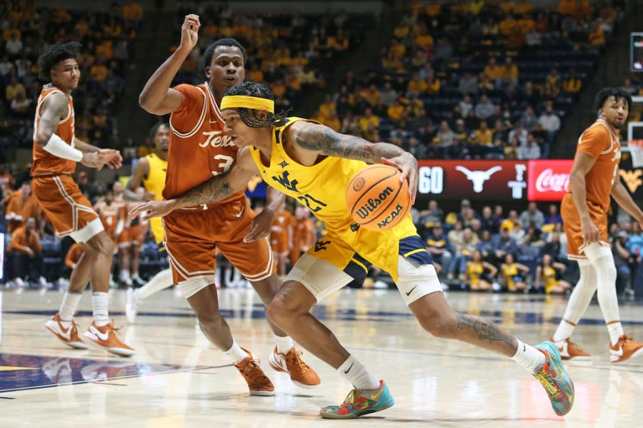 West Virginia guard RaeQuan Battle (21) is defended by Texas guard Max Abmas (3) during the second half of an NCAA college basketball game on Saturday, Jan. 13, 2024, in Morgantown, W.Va. (AP Photo/Kathleen Batten)