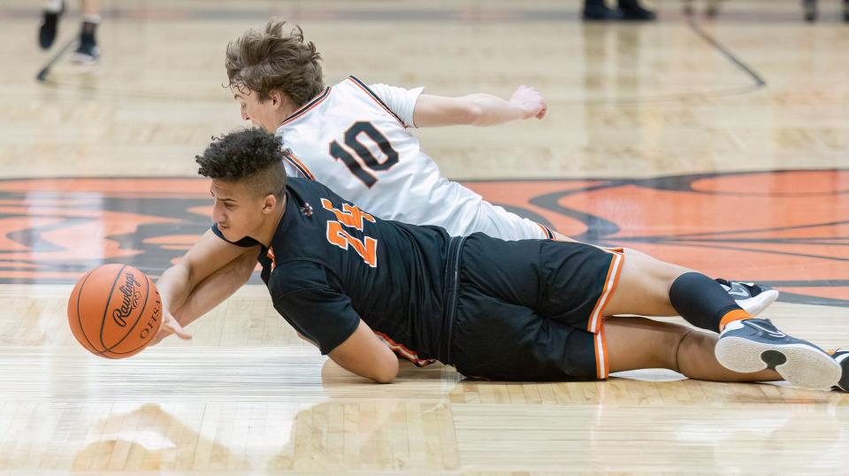 Massillon’s Elijah Farrington (24) and Hoover’s Wesley Collins (10) go after a loose ball Friday, Jan. 6, 2023.