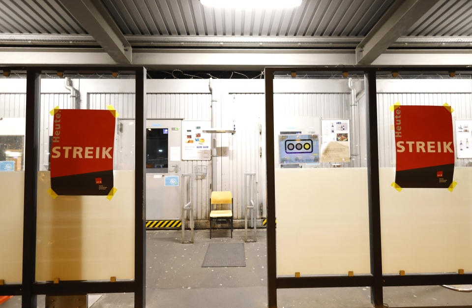 Posters reading "Strike today" are hanging at the personnel entrance for airport employees at Cologne Bonn Airport in Cologne, Germany, Sunday, Feb. 26, 2023. Airport employees in aviation security at Cologne Bonn Airport have been on strike for better wages since this evening. (Thomas Banneyer/dpa via AP)