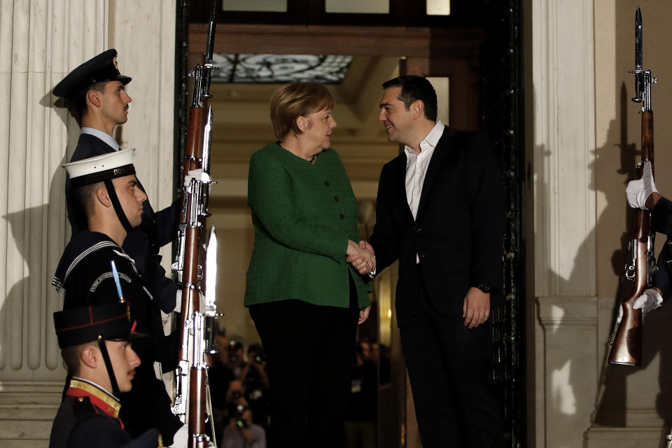 Greek Prime Minister Alexis Tsipras, right, shakes hands with German Chancellor Angela Merkel during a welcome ceremony in Athens, Thursday Jan. 10, 2019. Merkel is in Greece for talks. (AP Photo/Thanassis Stavrakis)