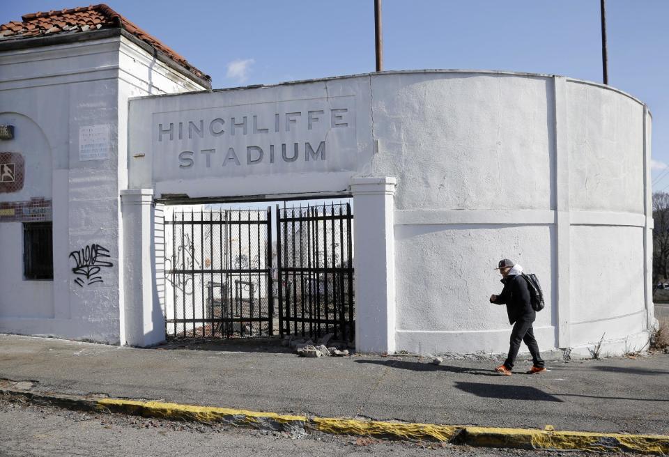 A man walks past an entrance to Hinchliffe Stadium in Paterson, N.J. on Thursday, March 14, 2013. Hinchliffe, built as a public works project municipal stadium in 1932, now sits in disuse, with trees growing in the graffiti covered stands and a deteriorated artificial turf surface. The once-grand Art Deco stadium earned designation in March as a national landmark - less than two years after the nearby Great Falls, a powerful 77-foot waterfall that helped fuel the Industrial Revolution, became a national park. (AP Photo/Mel Evans)