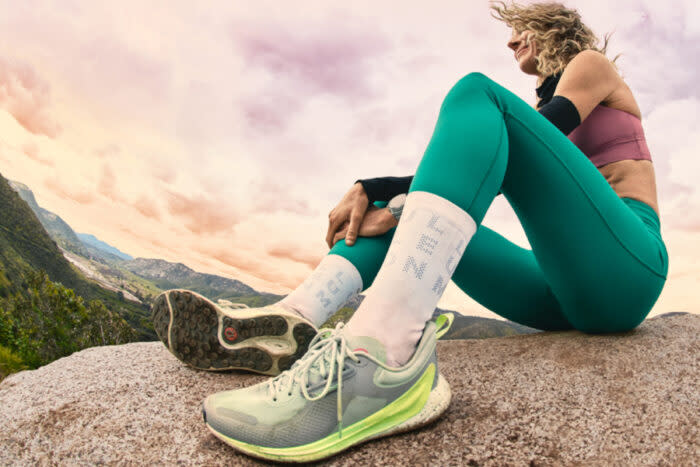 woman sitting on rock in sports bra