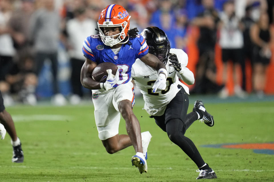 Florida wide receiver Tank Hawkins, left, runs for yardage after a reception past Central Florida defensive back Mac McWilliams during the first half of an NCAA college football game, Saturday, Oct. 5, 2024, in Gainesville, Fla. (AP Photo/John Raoux)