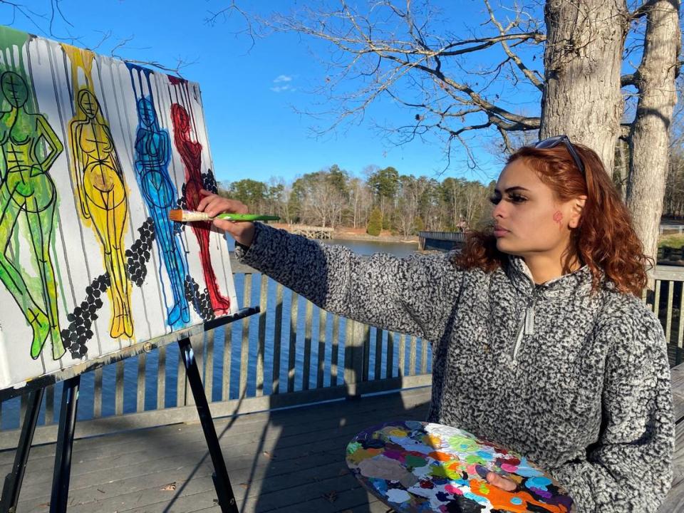 Charlotte artist Arelys Ripoll works lakeside on a piece she calls “Emotions.”