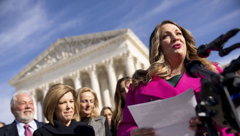 Lorie Smith, a Christian graphic artist and website designer in Colorado, right, accompanied by her lawyer, Kristen Waggoner of the Alliance Defending Freedom, second from left, speaks outside the Supreme Court in Washington on Dec. 5, 2022, after her case was heard before the Supreme Court.