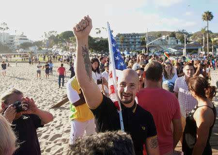 Demonstrator Johnny Benitez pumps his fist into the air during an America First rally in Laguna Beach, California, U.S., August 20, 2017. REUTERS/Sandy Huffaker