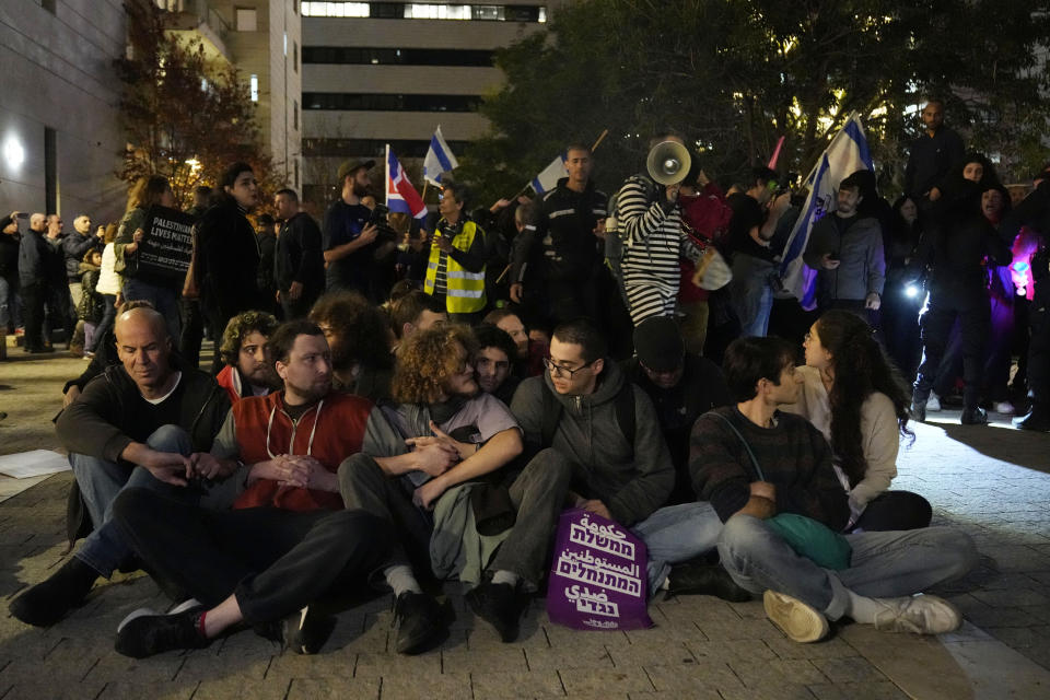 Activists lock arms in Tel Aviv, Israel, to protest against Prime Minister Benjamin Netanyahu's far-right government, Saturday, Jan. 7, 2023. Thousands of Israelis protested plans by Netanyahu's government that opponents say threaten democracy and freedoms. (AP Photo/ Tsafrir Abayov)