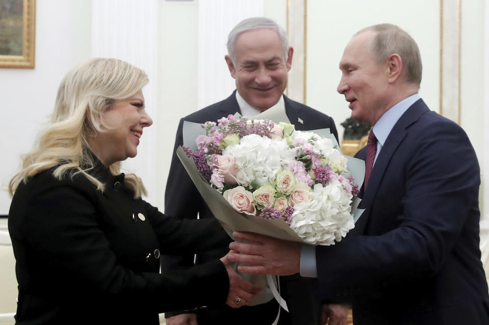 Russian President Vladimir Putin, right, greets Israeli Prime Minister Benjamin Netanyahu's wife Sara, left, as Israeli Prime Minister Benjamin Netanyahu stands at centre, prior to their talks in the Kremlin in Moscow, Russia, Thursday, Jan. 30, 2020. Netanyahu visited Moscow to discuss the U.S. Mideast peace plan with Putin and take an Israeli woman who had been jailed in Russia back home. (Maxim Shemetov/Pool Photo via AP)