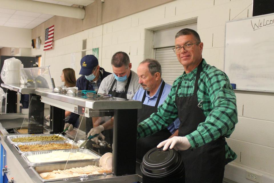 Kiwanians Todd Carver, (front), Jim Koehn, Mark Haag and Kurt Kominek dish up meals for distribution on Thursday.