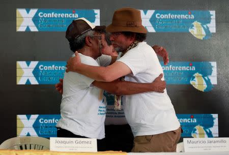 Revolutionary Armed Forces of Colombia's (FARC) Joaquin Gomez and Pastor Alape hug each other after a news conference at the camp where they prepare for ratifying a peace deal with the Colombian government, near El Diamante in Yari Plains, Colombia, September 23, 2016. REUTERS/John Vizcaino